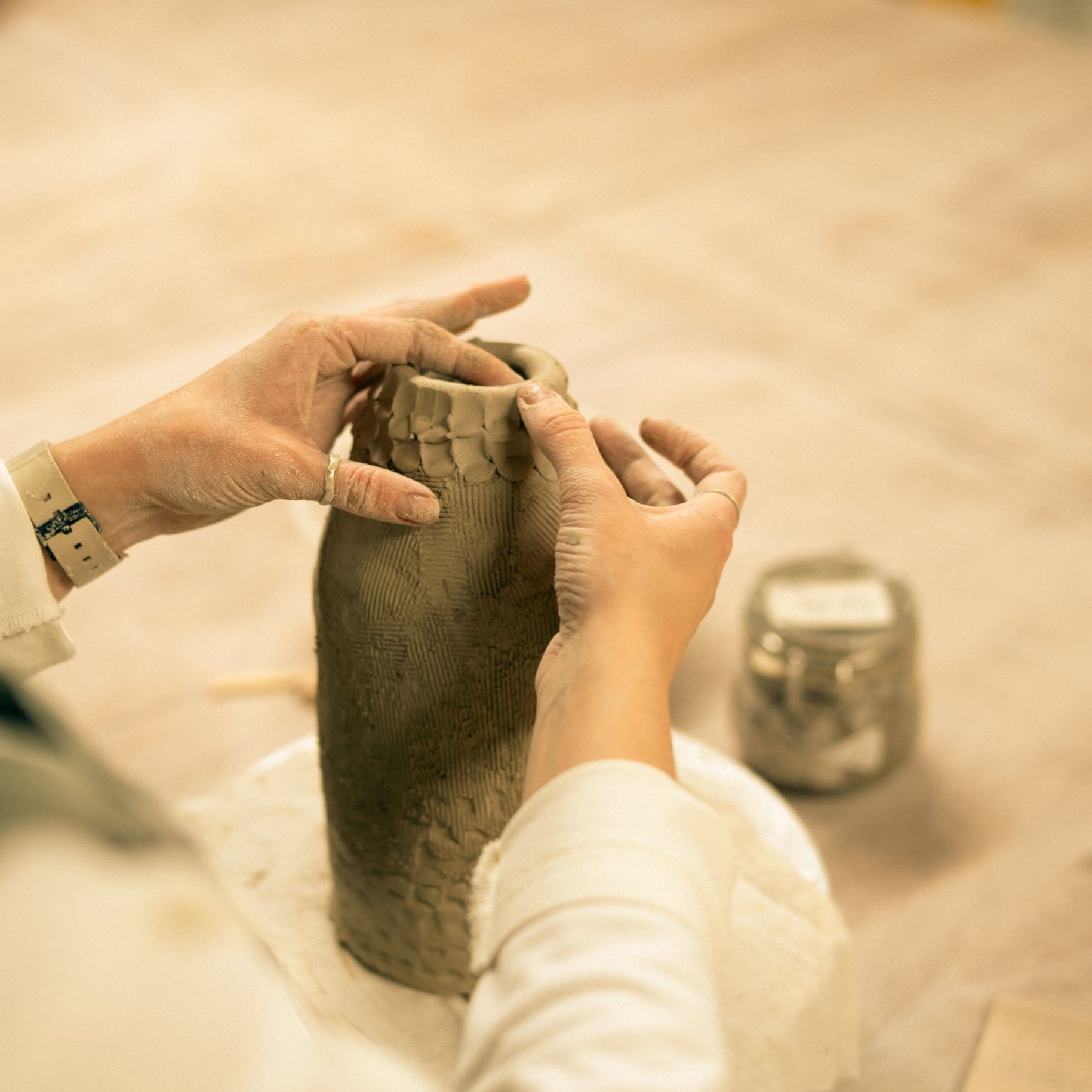 Throwing Shapes teacher Aine hand-builds in clay on a wooden bench